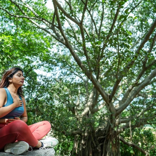 Woman sitting in a serene yoga meditation pose in a calm environment.